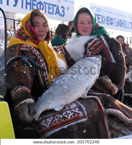 Nadym, Russia - March 11, 2005: the national holiday, the day of the reindeer herder in Nadym, Russia - March 11, 2005. Unknown woman - Nenets, sell huge Northern fish, muksun.