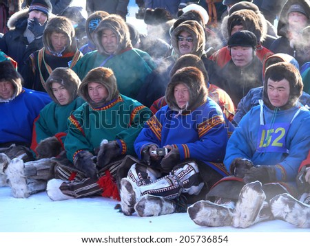 Nadym, Russia - March 15, 2008: the national holiday - the Day of the reindeer herder in Nadym, Russia - March 15, 2008. A crowd of unfamiliar men Nenets sit and watch the view.