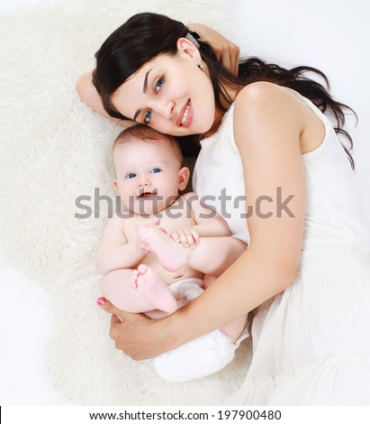 Happy mom and charming baby lying in the bed, sleep, bedtime, top view