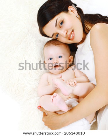 Happy mom and charming baby lying in the bed, sleep, bedtime, top view