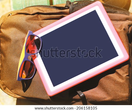 Fashion summer hipster concept, screen tablet pc and sunglasses on the backpack