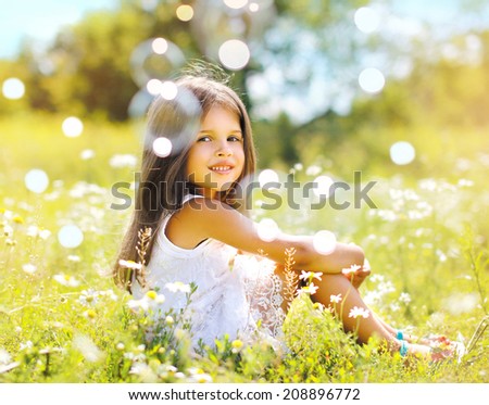 Child with soap bubbles having fun in summer day