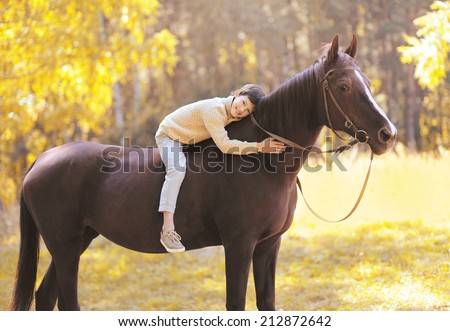Autumn season happy teenager boy on the horse in the forest