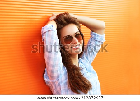 Summer fashion portrait pretty woman in sunglasses posing against colorful wall, street fashion