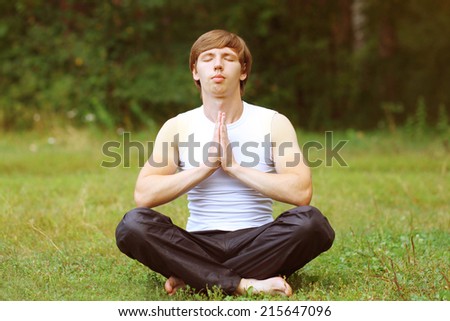 Yoga man relaxation on the grass