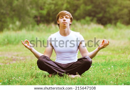 Yoga man relaxation outdoors on the grass