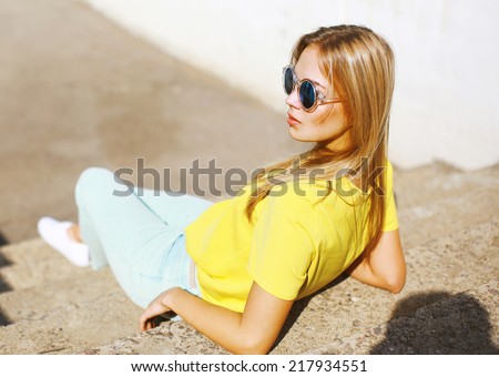 Street fashion, stylish pretty hipster girl in sunglasses posing in the city