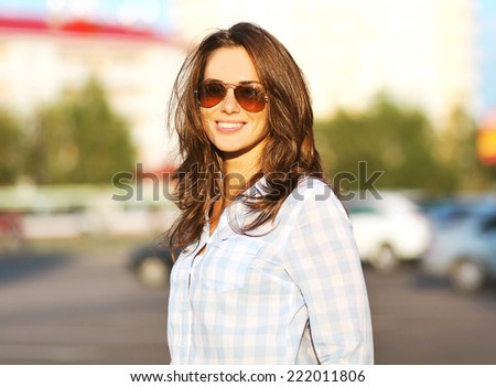 Fashion summer lifestyle portrait beautiful woman in sunglasses posing in the city, evening sunset sunny light, street fashion