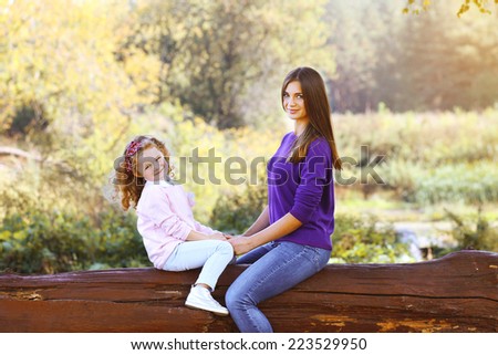 Mother and daughter walking in the park outdoors