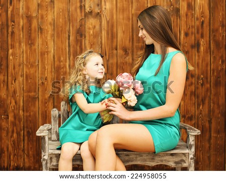 Mother\'s day, holiday, christmas, birthday concept - beautiful mother and daughter, little girl gives bouquet flowers mother
