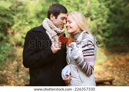 Christmas and people concept - happy pretty young couple in love outdoors against christmas tree in winter day