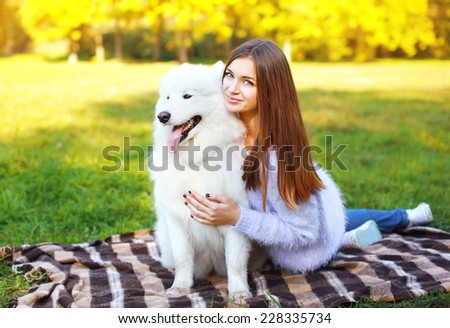 Pretty happy woman and dog outdoors in warm sunny day