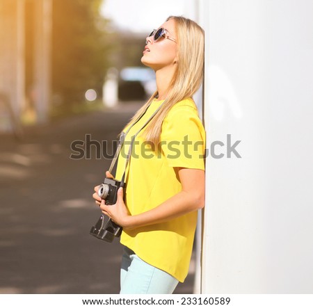 Summer, fashion and people concept - stylish pretty sensual girl in sunglasses with retro vintage camera enjoying in city, street fashion