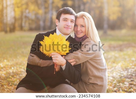 Autumn, love, relationships and people concept - pretty young couple outdoors in sunny autumn park