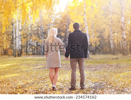 Autumn, love, relationships and people concept - silhouette of young couple outdoors in sunny autumn park