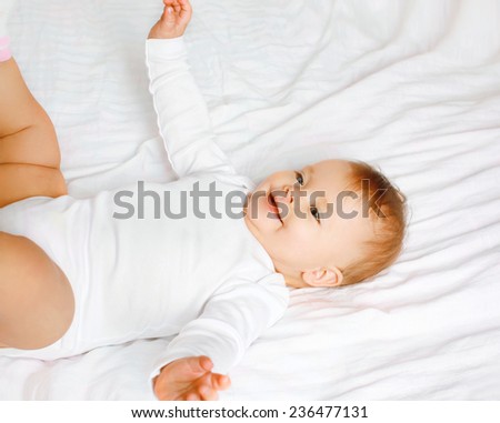 Sweet baby lying on the bed, top view