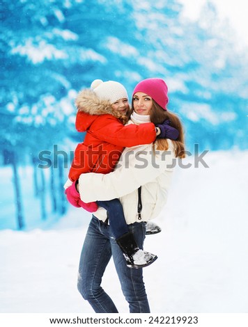 Winter and people concept - young mother and child walking in snowy day