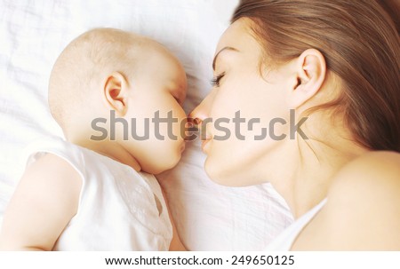 Baby and mother sleeping together on the bed