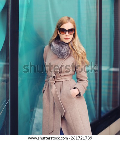 Portrait of stylish elegant woman in coat and sunglasses outdoors