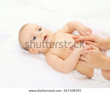 Baby massage lying on the back at home on the bed