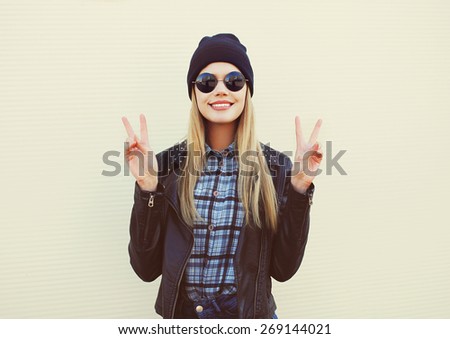 Fashion portrait of pretty blonde girl in trendy rock style posing and having fun outdoors