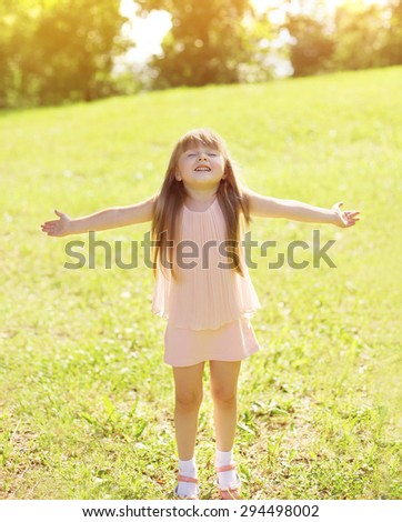 Sunny photo happy little girl child enjoying summer day and having fun outdoors