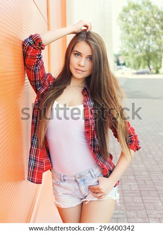 Fashion portrait of pretty woman model in checkered shirt with long hair outdoors
