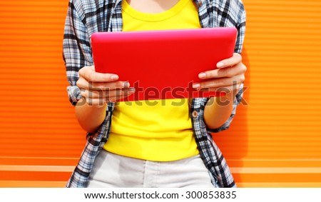Female hands holding digital tablet pc, young woman using tablet computer in the city