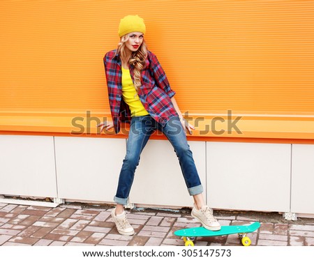 Fashion pretty woman wearing casual colorful clothes with skateboard in the city