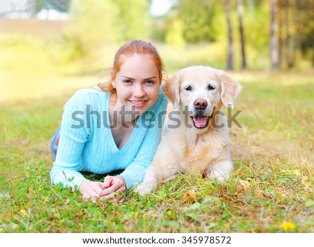 Portrait happy smiling owner woman and Golden Retriever dog lying on grass