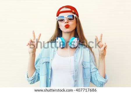 Pretty cool woman in sunglasses and red cap having fun over white background
