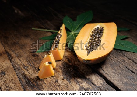 papaya with green papaya leaf on old wood.