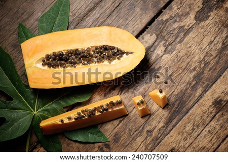 papaya with green papaya leaf on old wood.