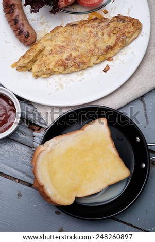 American Breakfast set with sausage omelette and  salad on blue wooden table