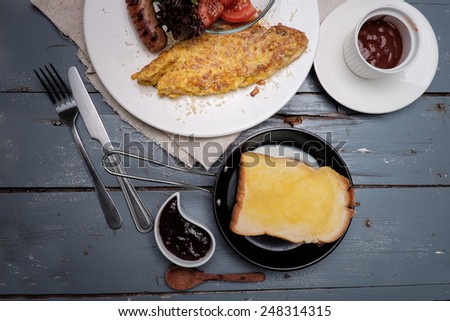 American Breakfast set with sausage omelette and salad on blue wooden table