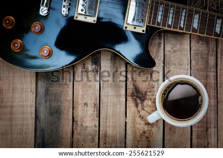 Vintage guitar and coffee on old wooden texture