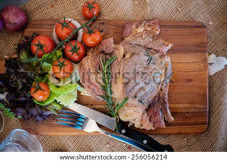 Beef ribeye steak with knife and fork for meat on cutting board