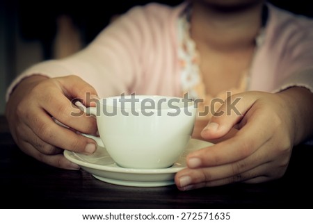 young woman holding hot cup of coffee ,Vintage effect