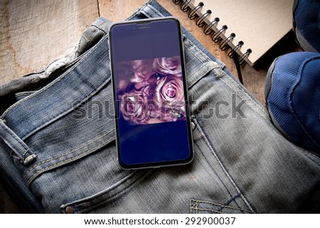 Smart phone show screen of flower on jean
