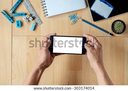 A businessman holding empty screen of smart phone on a desk work