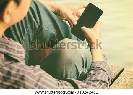 A man using mobile smart phone,vintage effect.