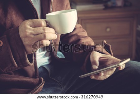 Man drink coffee and using smart phone