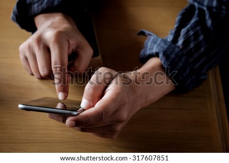 Close up of a man using mobile smart phone.vintage effect.