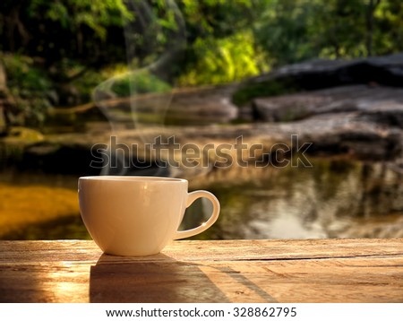 cup of coffee with water fall at morning sunrise.