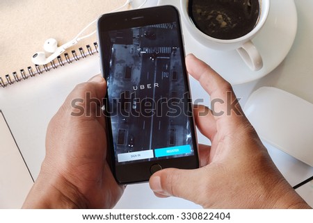 CHIANG MAI,THAILAND - OCT 24,2015 :  A man hand holding Uber app showing on iPhone 6 plus,Uber is smartphone app-based transportation network.