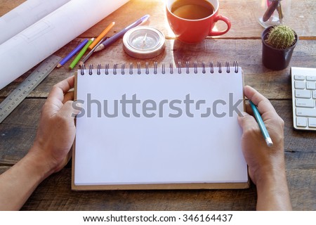 Blank paper note in female hand for any idea on desk work.