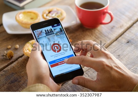 CHIANG MAI,THAILAND - DEC 17,2015 : Man holding a iPhone 6 Plus with social Internet service Pinterest on the screen. iPhone 6 Plus was created and developed by the Apple inc.