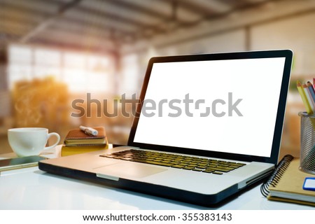 Side view of empty screen laptop on desk work in warehouse background.