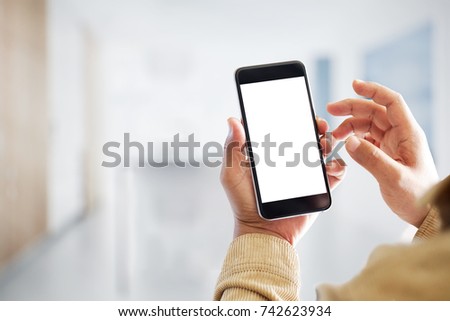 Mock up smartphone blank screen in man hands in blurred office interior background.