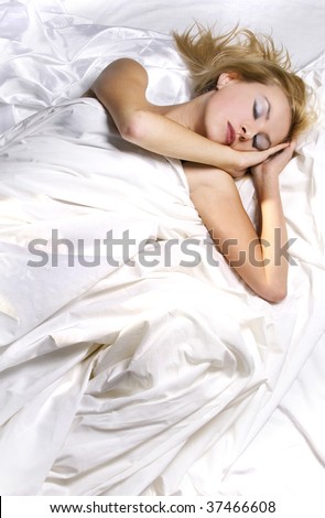 Girl asleep in bed wrapped in white sheets